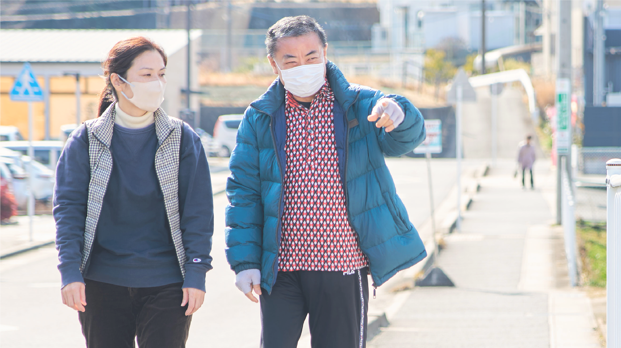 散歩する高齢者を見守るヘルパー